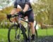 a man riding a bike down a muddy road
