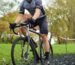 a man riding a bike down a muddy road